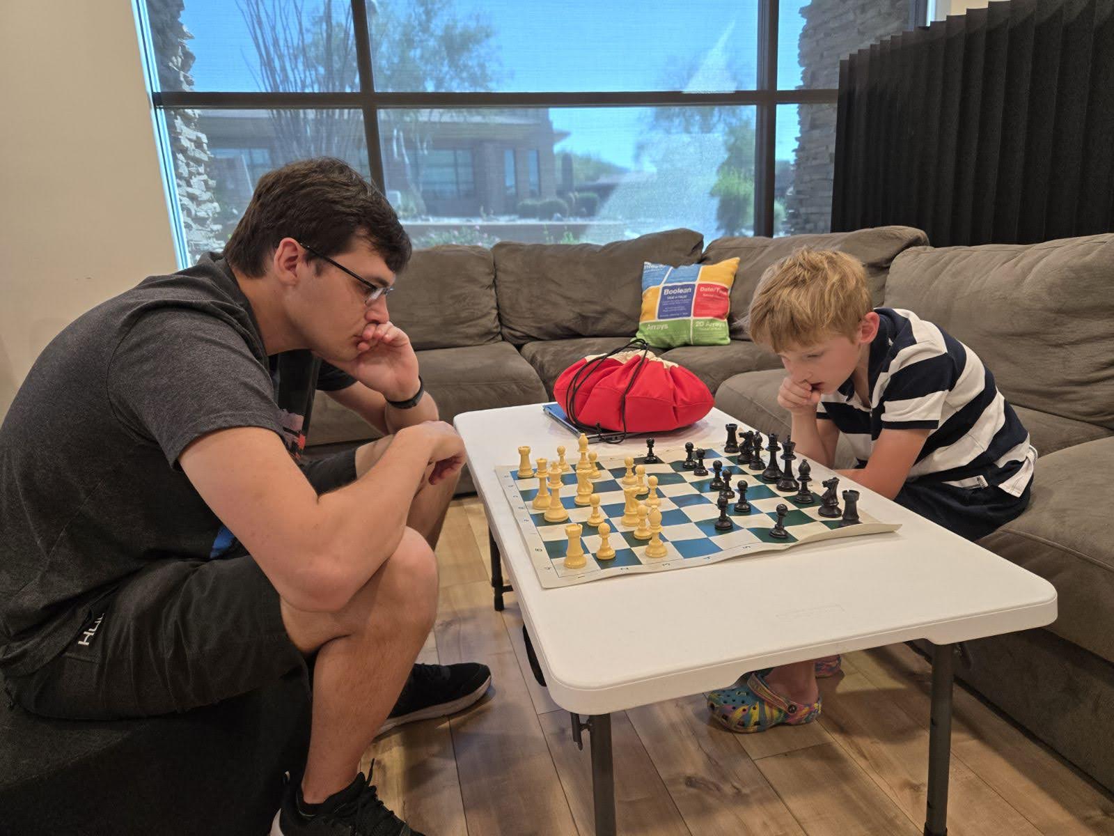 A student thinking over a chess board